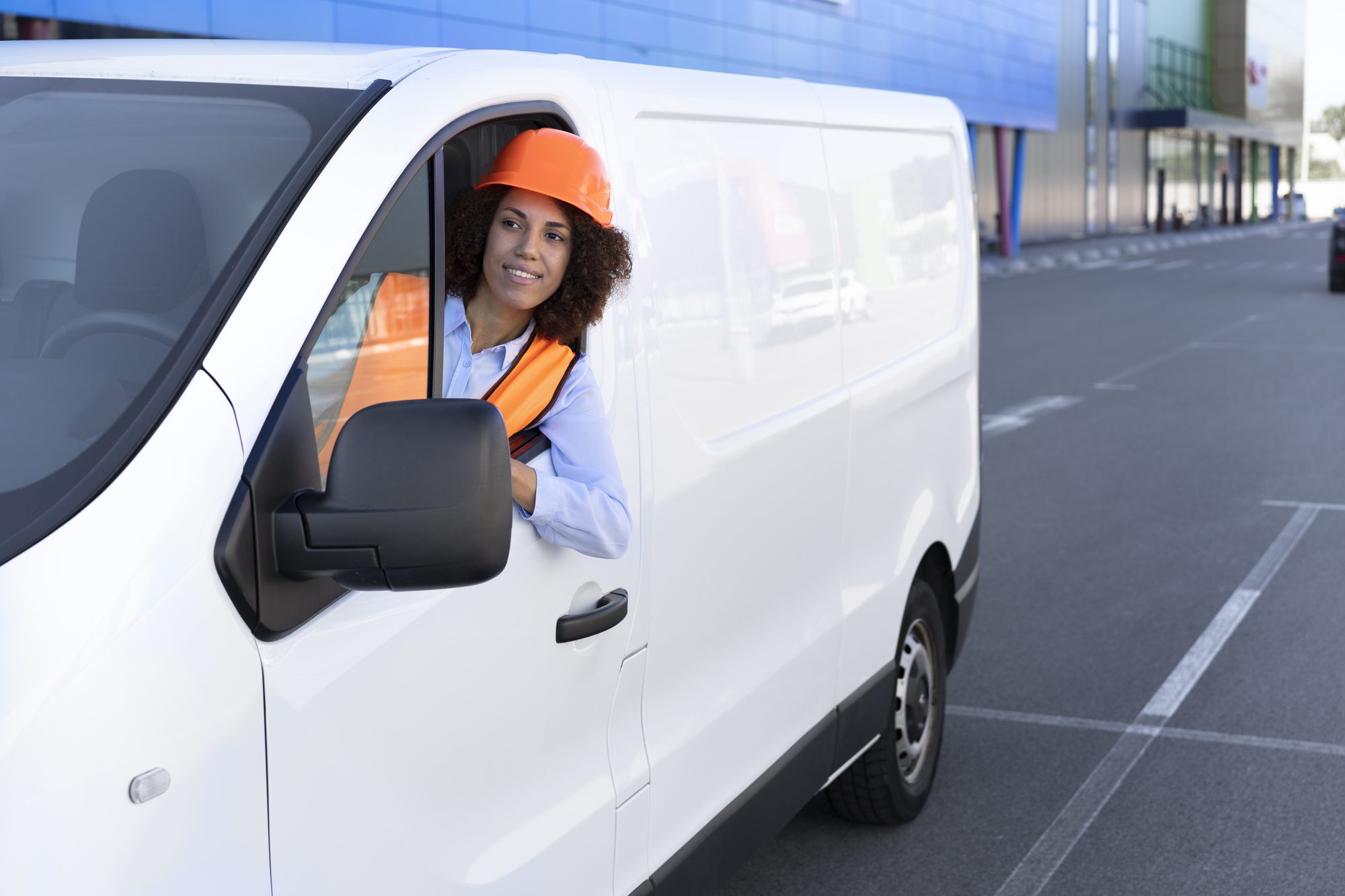 Driver smiling from the window of a white van