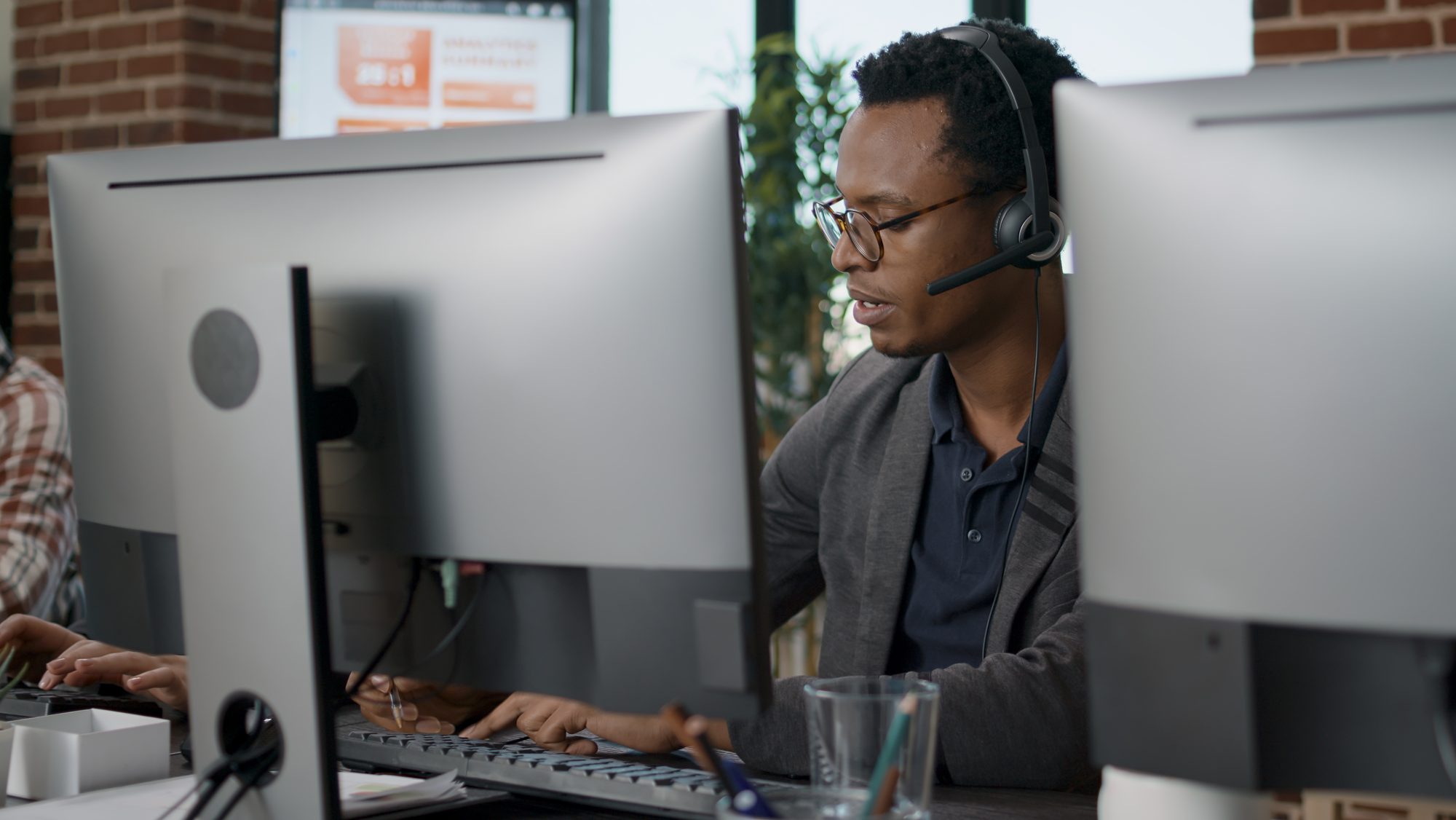 Dispatcher wearing a headset answering a booking call at his desk