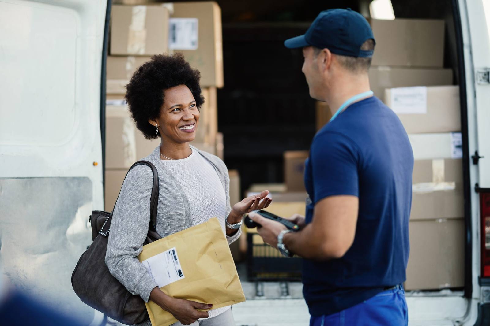Courier handing a package to a smiling customer
