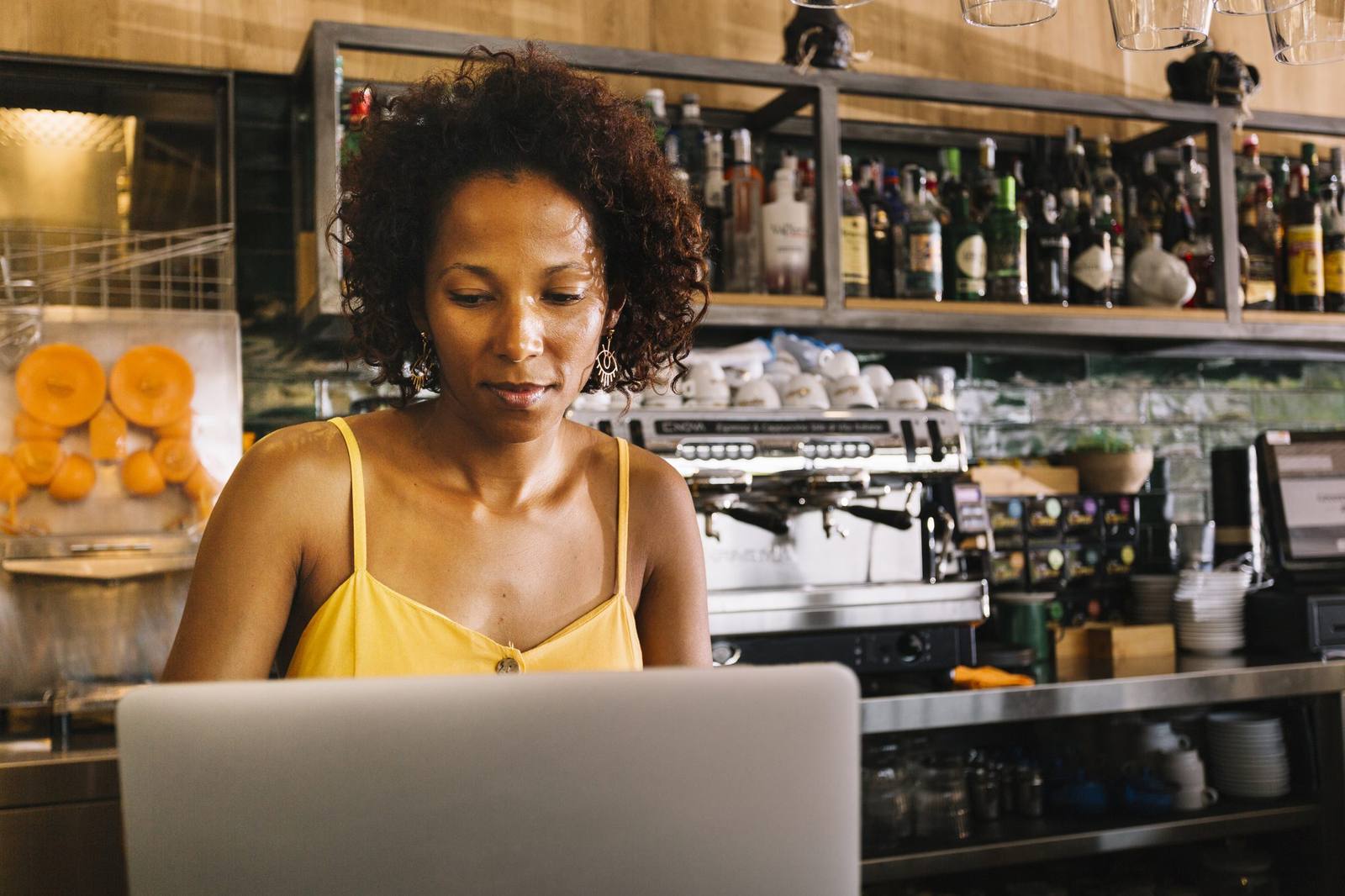 Business owner booking a delivery on a laptop in a café